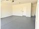 Spacious garage featuring a gray epoxy floor, white walls, and an entrance door to the house at 3431 Cottage Thistle Dr, Laughlin, NV 89029