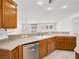 Kitchen sink with stainless steel dishwasher, light counter tops, and wooden cabinets at 3431 Cottage Thistle Dr, Laughlin, NV 89029