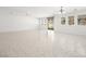 Large living room with neutral tile flooring, ample natural light, and access to outdoor space at 3431 Cottage Thistle Dr, Laughlin, NV 89029