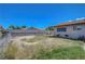 A spacious backyard awaits personalization, with a fence, a home, and a clear blue sky at 3630 N Pecos Rd, Las Vegas, NV 89115
