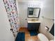 This is a bathroom featuring a floral shower curtain and a blue vanity at 378 W Thomas Ave, Overton, NV 89040