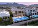 Stunning aerial view of a home with a backyard pool and mountains, showcasing the community and desert landscape at 390 Coastal Redwood St, Las Vegas, NV 89138