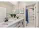 Bright bathroom with double sinks, granite countertops, and framed mirrors, leading to separate toilet and shower space at 390 Coastal Redwood St, Las Vegas, NV 89138