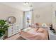 Bright bedroom with a large window, white dresser, and a cozy bed with patterned quilt and decorative pillows at 390 Coastal Redwood St, Las Vegas, NV 89138