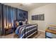 Cozy bedroom features a black iron bed frame, unique decorations, and is lit by a pendant bedside table lamp at 390 Coastal Redwood St, Las Vegas, NV 89138