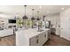 The kitchen features an island with bar stools and pendant lights, along with stainless steel appliances at 390 Coastal Redwood St, Las Vegas, NV 89138