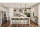 A kitchen has an island with bar stools, stainless steel appliances, and modern pendant lighting at 390 Coastal Redwood St, Las Vegas, NV 89138