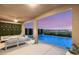A covered patio with comfortable seating overlooks a pool and landscaped backyard at 390 Coastal Redwood St, Las Vegas, NV 89138