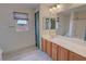 Bathroom featuring a wood cabinet, double mirrors, light fixture, and tiled floor at 3938 E Chaffe Ave, Pahrump, NV 89061
