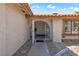 Inviting front entrance showcasing an arched gate, tiled roof, and textured stucco walls under a partly cloudy sky at 3941 Boca Grande Ave, Las Vegas, NV 89120