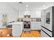 Bright kitchen features white cabinets, modern appliances, breakfast bar, and wood flooring at 3941 Boca Grande Ave, Las Vegas, NV 89120