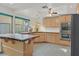 Well-lit kitchen with tile countertops, wood cabinets, stainless steel appliances, and a center island at 3989 Parkhaven Dr, Las Vegas, NV 89120