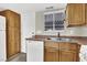 Kitchen featuring wood cabinets, tile flooring, and white appliances by the exterior access door at 433 Sellers Pl, Henderson, NV 89011