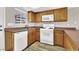 Cozy kitchen with wooden cabinets, white appliances, and tile flooring at 433 Sellers Pl, Henderson, NV 89011