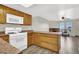 Open kitchen leading to the living room with wooden cabinets, tile flooring, and white appliances at 433 Sellers Pl, Henderson, NV 89011