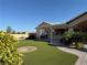 Lush backyard with an outdoor kitchen under covered patio and green turf at 4455 W Ford Ave, Las Vegas, NV 89139