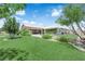Expansive backyard featuring a large lawn, mature landscaping, and a glimpse of the covered patio and outdoor fire pit at 4455 W Ford Ave, Las Vegas, NV 89139