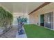 Back patio with synthetic grass, desert landscaping, and sliding glass door to inside the home at 4455 W Ford Ave, Las Vegas, NV 89139