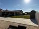 Manicured backyard featuring artificial turf, mature trees, and a covered patio at 4455 W Ford Ave, Las Vegas, NV 89139