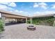 A vast backyard patio featuring a stone fire pit, leading to a covered dining area and views of the green surroundings at 4455 W Ford Ave, Las Vegas, NV 89139