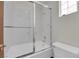 Bright bathroom featuring a shower-over-tub with clear glass doors and a white tile surround at 4455 W Ford Ave, Las Vegas, NV 89139