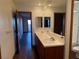 Bright bathroom featuring a double sink vanity with white countertops and a view of the adjacent bedroom at 4455 W Ford Ave, Las Vegas, NV 89139