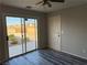 Bedroom with sliding glass door to patio, white door, and grey wood-look floors at 4455 W Ford Ave, Las Vegas, NV 89139