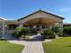 Wide covered patio with brick flooring, ceiling fans and lush green landscaping at 4455 W Ford Ave, Las Vegas, NV 89139