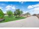 Long driveway leading to a landscaped backyard with desert-friendly plants, artificial turf, and a glimpse of the home at 4455 W Ford Ave, Las Vegas, NV 89139