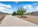 Long driveway leading to a landscaped backyard with desert-friendly plants, artificial turf, and patio with shade covering at 4455 W Ford Ave, Las Vegas, NV 89139