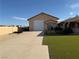 Home exterior view of an attached single-car garage, grass and gravel yard at 4455 W Ford Ave, Las Vegas, NV 89139