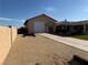 Exterior view with gravel backyard, long driveway and a single-car garage at 4455 W Ford Ave, Las Vegas, NV 89139