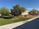 Front yard view of well-maintained lawn, mature trees, and partial sidewalk view at 4455 W Ford Ave, Las Vegas, NV 89139