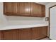 A well-lit laundry room featuring wooden cabinets and a white countertop for folding at 4455 W Ford Ave, Las Vegas, NV 89139