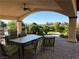 Relaxing covered patio with dining area overlooking the well-maintained backyard with lush landscaping at 4455 W Ford Ave, Las Vegas, NV 89139