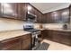 Traditional kitchen features dark wood cabinets, stainless steel appliances, and granite countertops at 4524 Stardusk Falls Ave, North Las Vegas, NV 89084