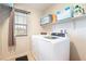 Bright laundry room with modern washer and dryer, storage shelves, and a window at 4524 Stardusk Falls Ave, North Las Vegas, NV 89084