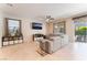 Spacious living room with tile floors, plush gray sectional couch, and backyard access at 4524 Stardusk Falls Ave, North Las Vegas, NV 89084