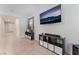 Bright living room features tile flooring, a media console, and a large wall-mounted television at 4524 Stardusk Falls Ave, North Las Vegas, NV 89084