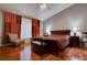 A spacious bedroom with red and orange curtains, hard wood floors and ceiling fan at 5000 Red Rock St # 237, Las Vegas, NV 89118