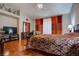 A spacious bedroom with red and orange curtains, hard wood floors and ceiling fan at 5000 Red Rock St # 237, Las Vegas, NV 89118