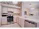 A kitchen is equipped with stainless steel appliances, white cabinetry and tiled countertops at 5000 Red Rock St # 237, Las Vegas, NV 89118