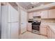 The kitchen features white appliances, a range, a microwave, and white cabinetry at 5000 Red Rock St # 237, Las Vegas, NV 89118