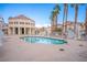 Community pool surrounded by lounge chairs and palm trees at this beautiful residential home complex at 5000 Red Rock St # 237, Las Vegas, NV 89118