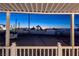 Outdoor covered patio with white railings showcasing city views at twilight, perfect for relaxation and entertainment at 54 E Texas Ave, Henderson, NV 89015