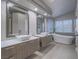 Luxury bathroom featuring dual vanities, a soaking tub, and modern fixtures at 5452 Big Sky Ln, Las Vegas, NV 89149