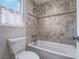 Updated bathroom featuring a bathtub/shower combo and tiled walls at 5452 Big Sky Ln, Las Vegas, NV 89149