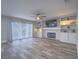 Open living room with fireplace, ceiling fan, built-in shelving, and sliding glass doors at 5452 Big Sky Ln, Las Vegas, NV 89149