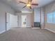 Spacious living room with a stone fireplace, neutral carpet, and a ceiling fan at 5452 Big Sky Ln, Las Vegas, NV 89149