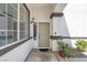 Close-up of a front door with sidelight window, exterior light fixture, and decorative potted plant at 5785 Farmhouse Ct, Las Vegas, NV 89141